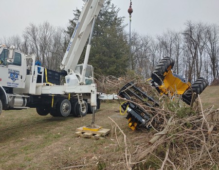 crane moves overturned excavator